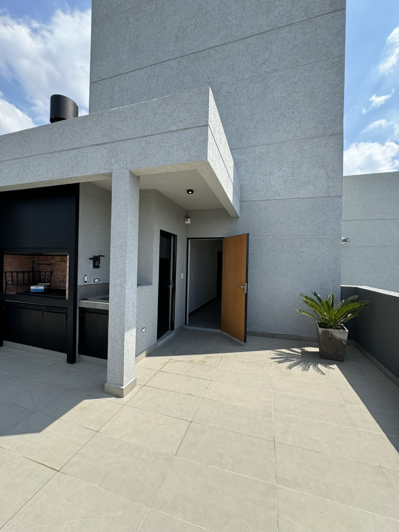 terraza con parrilla toilette y mesa con sillas
